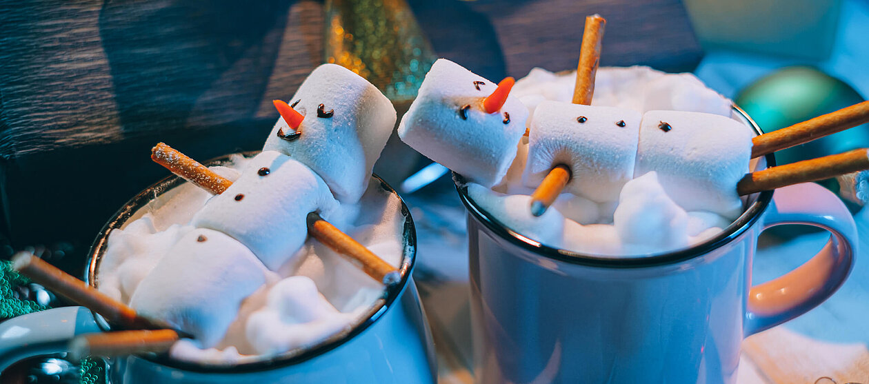 guter Winterstart Heißgetränk mit Marshmallow Männchen als Schneemann und Sahne